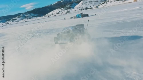 FPV drone chasing a buggy drifting on a frozen lake n winter.