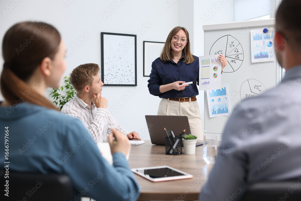 Fototapeta premium Business coach giving presentation to group of people in office