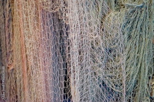 Close-up of colorful fishing nets hanging, detailed texture and pattern, symbol of fishing industry, tradition and marine life.