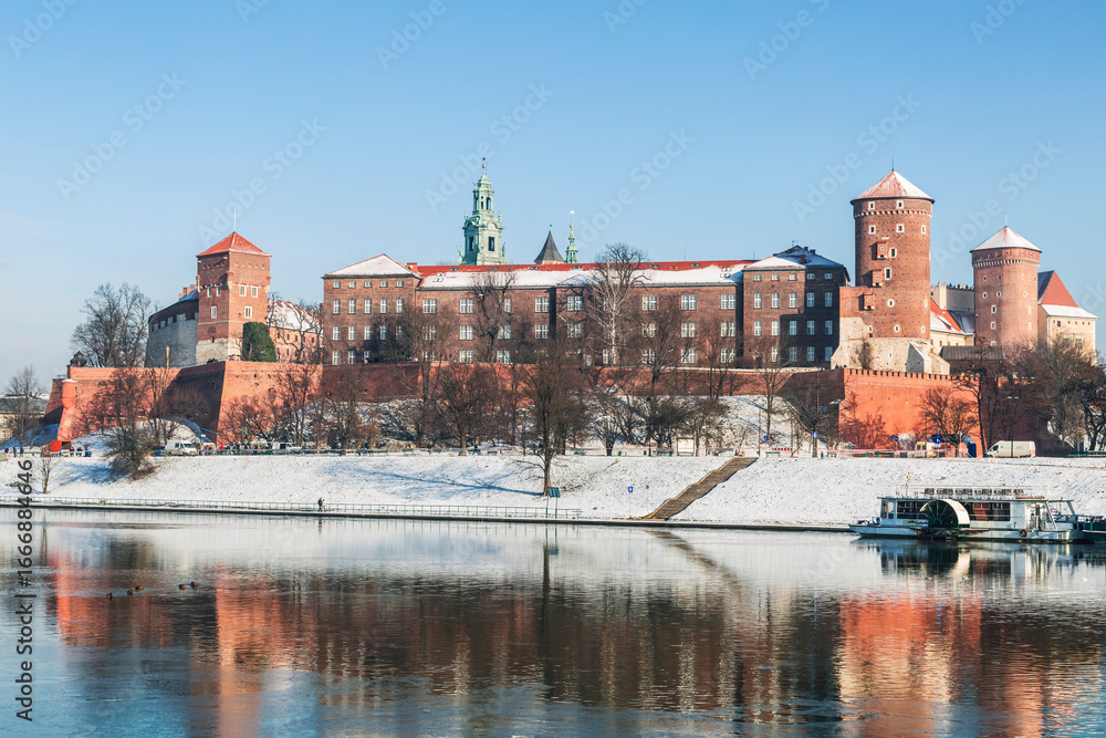 Obraz premium Winter view of the Royal Castle on Wawel hill on the banks of the Vistula River in Krakow. Poland