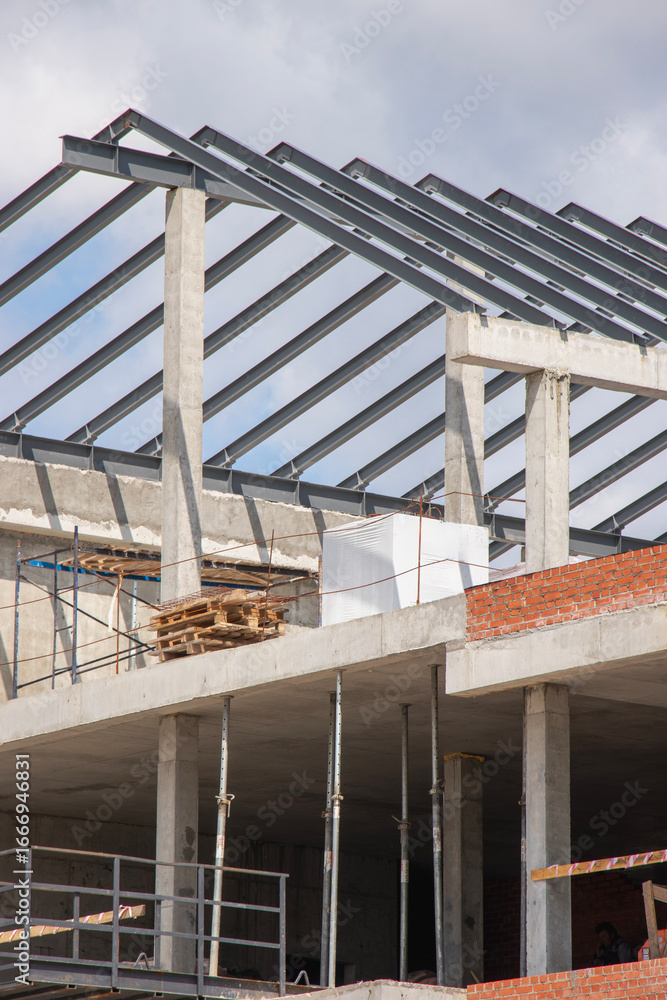 Obraz premium Construction of modern building framework under blue sky with visible structural elements