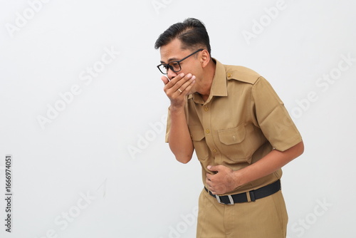Indonesian civil servant man covering mouth and holding belly. nauseous concept