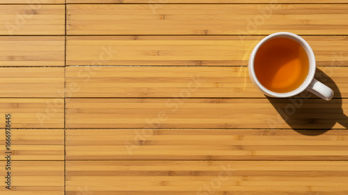 Relaxing tea break moment with a cup of herbal tea on a wooden table in the morning sunlight