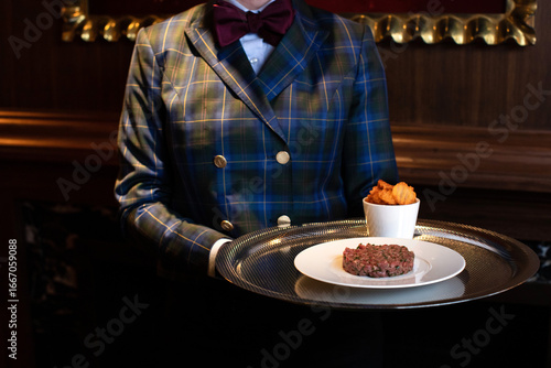 Wallpaper Mural Waitress Serving Beef Tartare on a silver Tray with Potatoes Torontodigital.ca