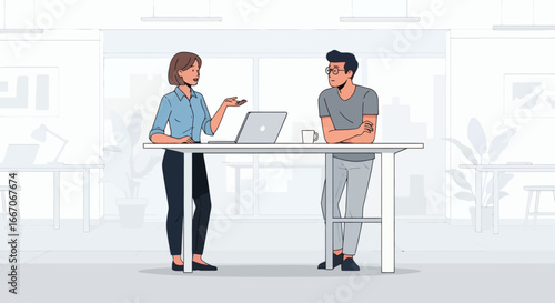 Woman speaking to man at standing desk with laptop and mug in a bright office environment