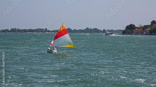 Wallpaper Mural Small Sailboat With Red And Yellow Sail Navigating Venetian Lagoon Near Islands With Clear Sky And Blue Water Waves Torontodigital.ca