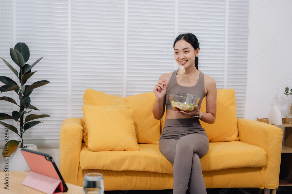 Obraz premium Healthy Woman Eating Salad on Sofa