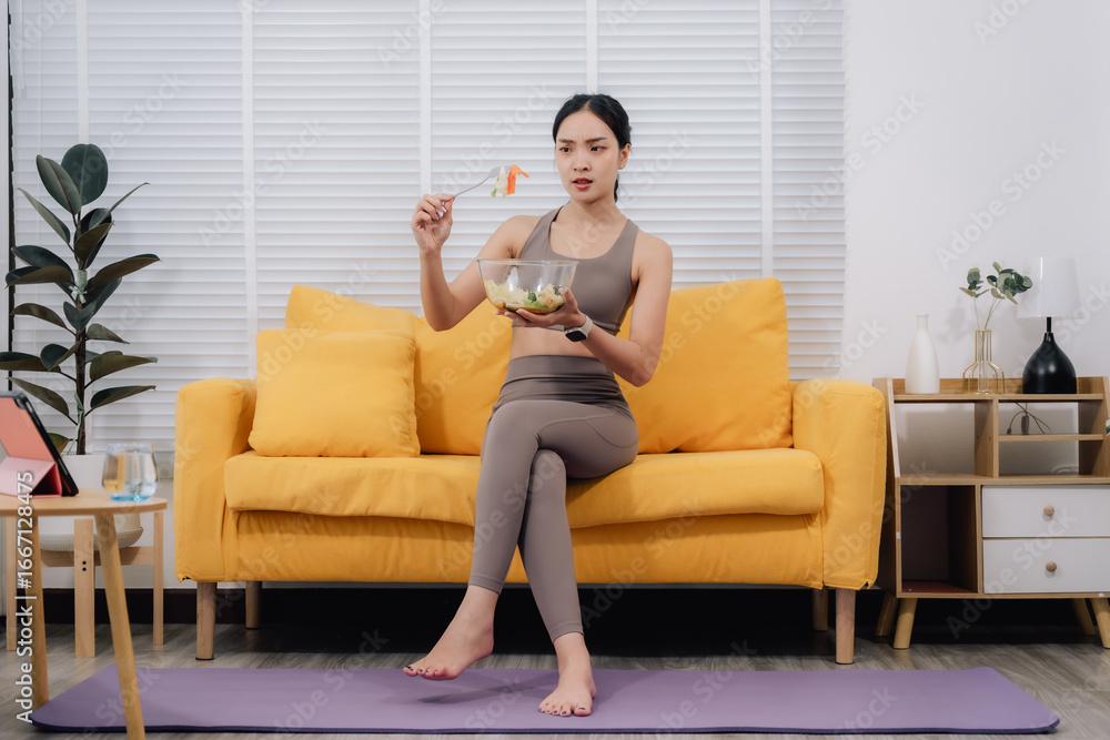 Obraz premium Woman Eating Salad After Online Yoga Class