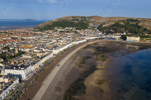 Wallpaper Mural Aerial view of Llandudno, Wales, showcasing the sweeping promenade lined with Victorian seafront buildings, the sandy beach at low tide, and the colourful townscape stretching inland. Torontodigital.ca