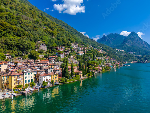 Lake Lugano, Italy. View of the lake, mountains and scenic village. A small Italian town by the lake on the boarder of Switzerland. Aerial drone view