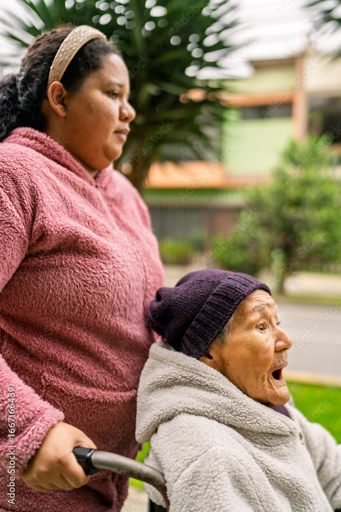 Nurse pushing elderly woman in wheelchair in park Nurse pushing elderly woman in wheelchair in park