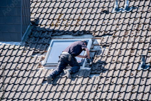 Foto Roofers working on a roof installing a skylight