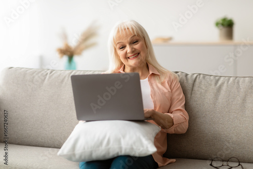 Free Download Technology And Seniors. Portrait Of Happy Elderly Woman Using Laptop At Home, Sitting With Pillow On The Couch In Living Room, Free Copy Space. Smiling Mature Woman Resting On Sofa - GFXLoad