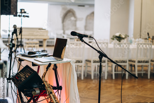 Elegant music setup with laptop, saxophone, and microphones prepared for a live performance in a sophisticated event venue wedding DJ musician 