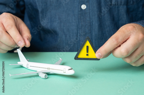 Photos A man holds a sign of attention near a passenger plane
