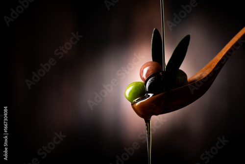 Olive branch soaked in olive oil on a wooden spoon