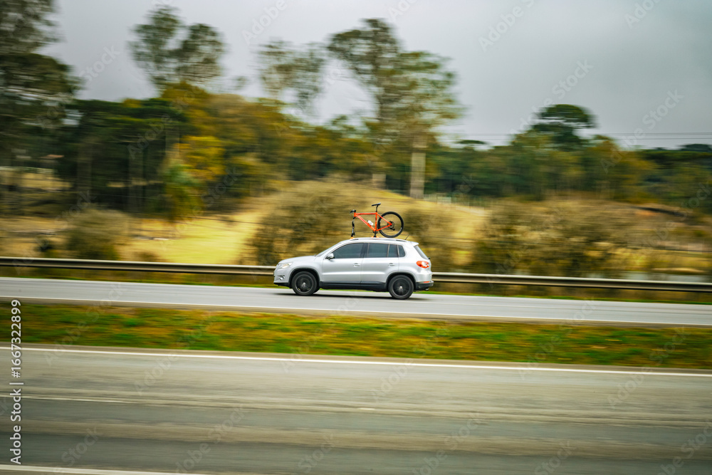 Obraz premium Adventure in Motion: Silver SUV with Rooftop Bike