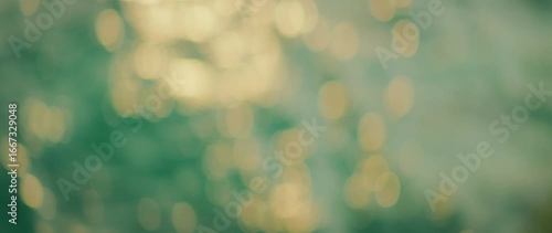 Out-of-focus golden sunlight reflecting on green sea water during sunset light