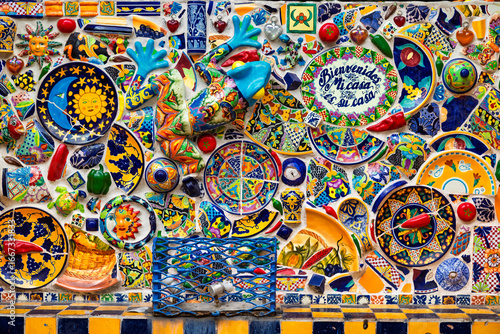 Colorful ceramic mosaic wall with plates, tiles and decorative objects, photographed in Santiago de Queretaro, Mexico