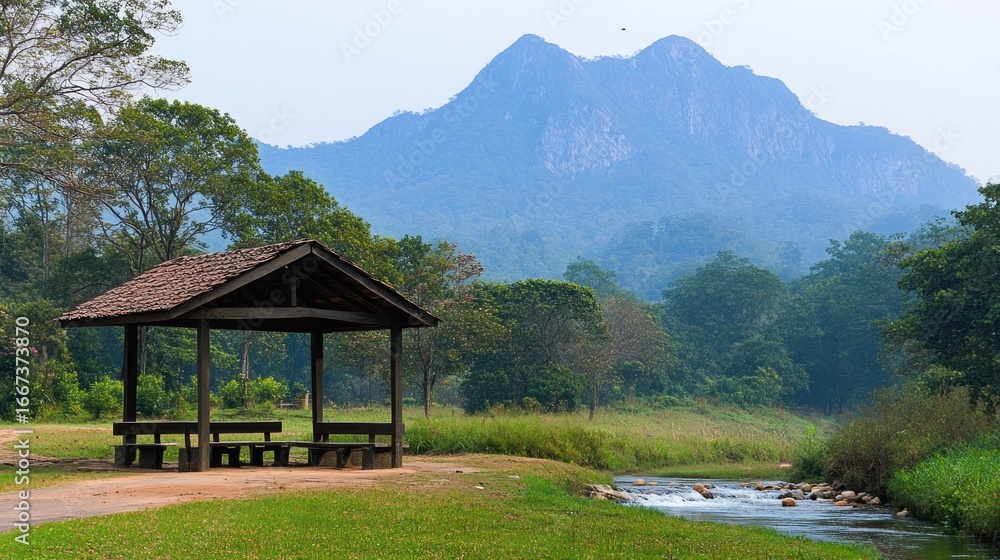 Fototapeta premium Wooden gazebo in a serene park, mountains in the background