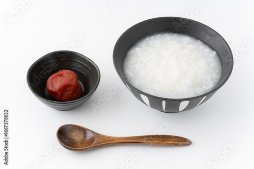 白背景に梅干しとお茶碗に入ったお粥