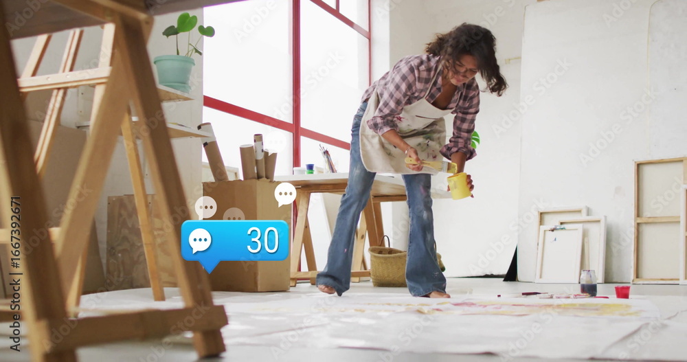 Naklejka premium Artist painting canvases wearing apron in art studio, with paintbrush yellow paint jar copy space