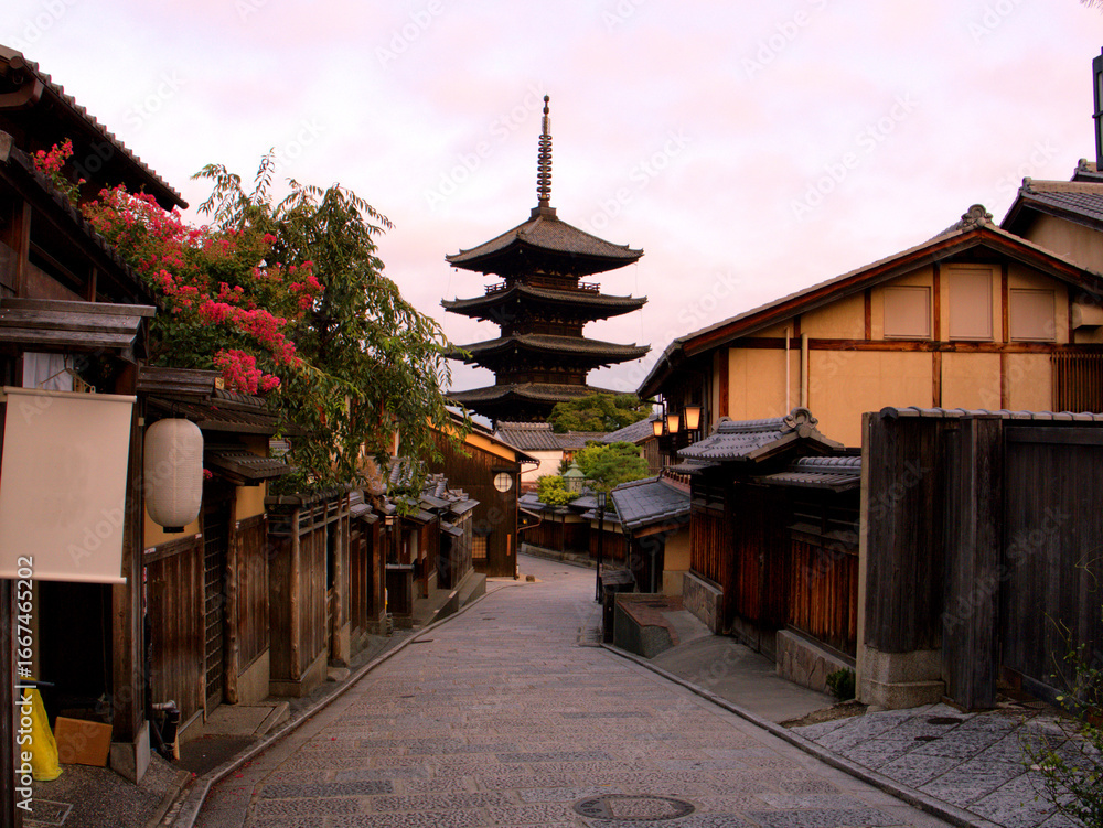 Naklejka premium ほんのりピンクに染まった朝焼けの空をバックに建つ、京都・清水寺近くの有名な観光スポットの八坂の塔(法観寺)