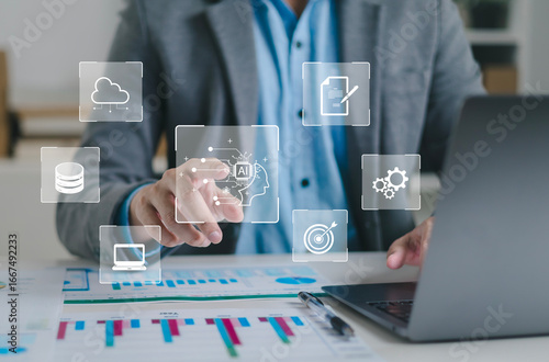 Tableau sur toile Businessman using laptop to control AI at desk in office