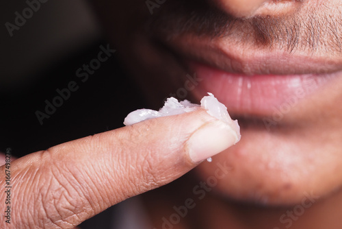 Foto Applying a topical treatment to the lips in a close-up view