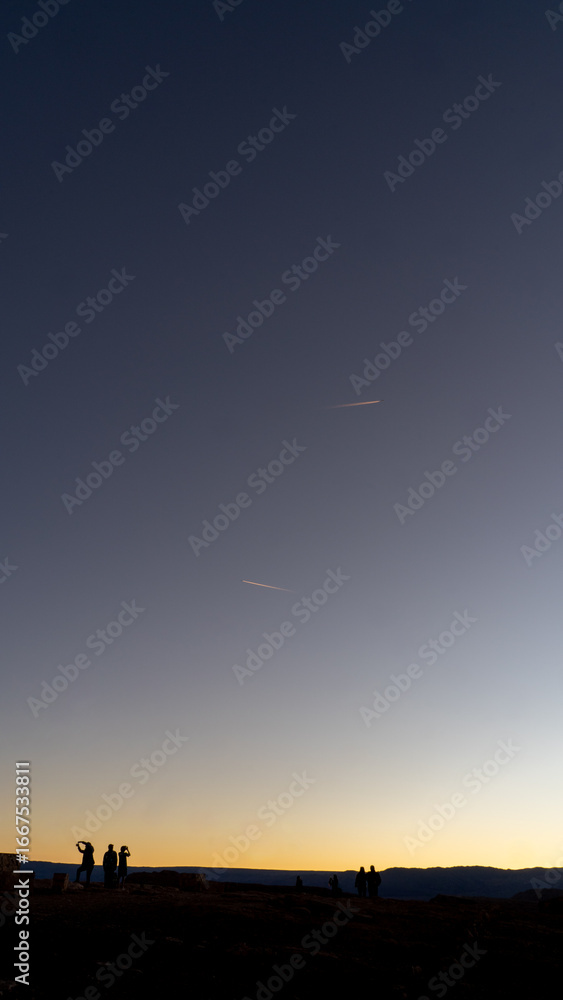 Obraz premium Minimalist sunset sky with two contrails and tiny silhouettes