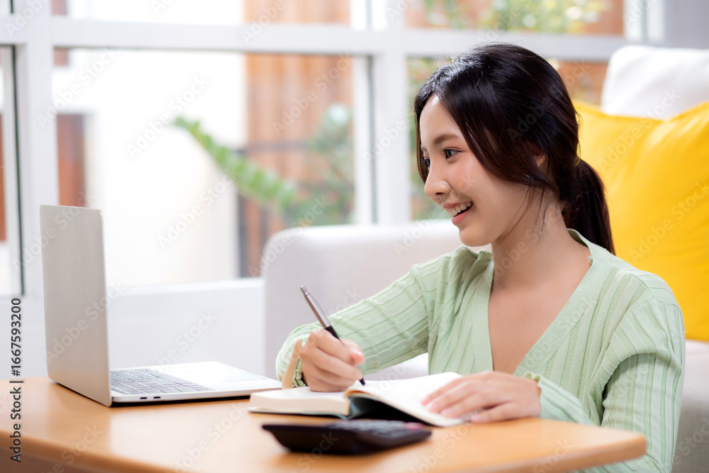 Young asian woman planning and strategy about finance and investment or tax while writing on textbook in living room at home, woman with expense and budget of home, business and finance. Young asian woman planning and strategy about finance and investment or tax while writing on textbook in living room at home, woman with expense and budget of home, business and finance.
