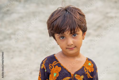 Murais de parede Little poor girl with innocent expression in refugee camp, symbolizing poverty,