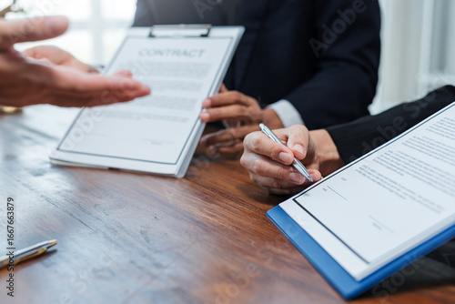 Fotografie Business partners signing a contract at an office desk, finalizing a deal and so