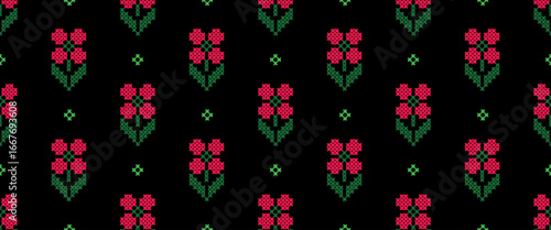 Seamless pattern with a cross-stitch embroidery effect. This traditional folk art design features pixelated red flowers and green leaves on a black background. A charming, vintage-style textile print.