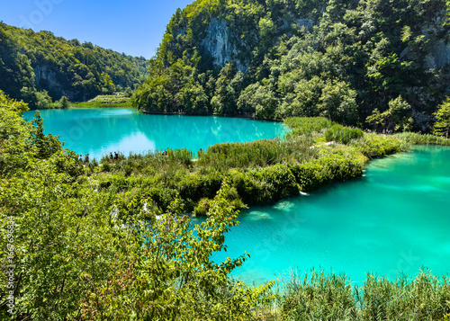 Footpath between lakes in Plitvice Lakes National Park, Croatia. UNESCO World Heritage and tourist attraction.