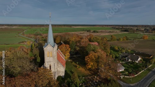 Aerial footage of one of the oldest churches in Estonia - Church of the Blessed Virgin Mary in Joelahtme (Estonian - Püha Neitsi Maarja kirik, Jõelähtme) on a sunny autumn day. 