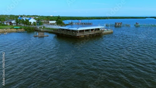 Wallpaper Mural Drone footage of a seaside dining spot with fish cages, native boats, and lush green surroundings along the Philippine coast. Torontodigital.ca