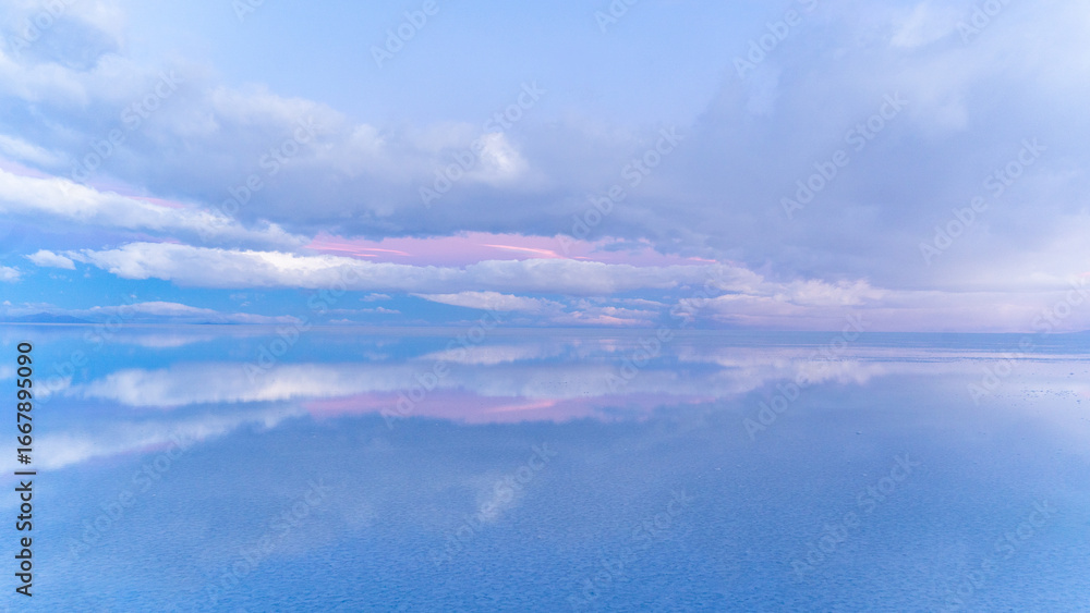 Obraz premium Dreamlike pastel sky and clouds with perfect reflection on Salar de Uyuni
