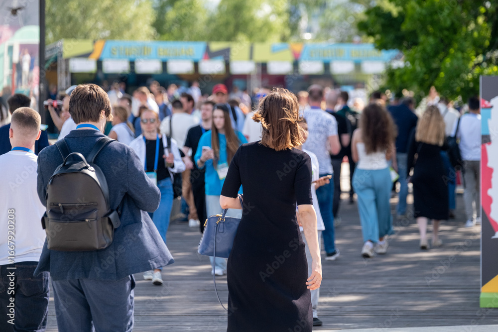 People walking and socializing in an outdoor event, exchanging ideas in a professional setting. People walking and socializing in an outdoor event, exchanging ideas in a professional setting.