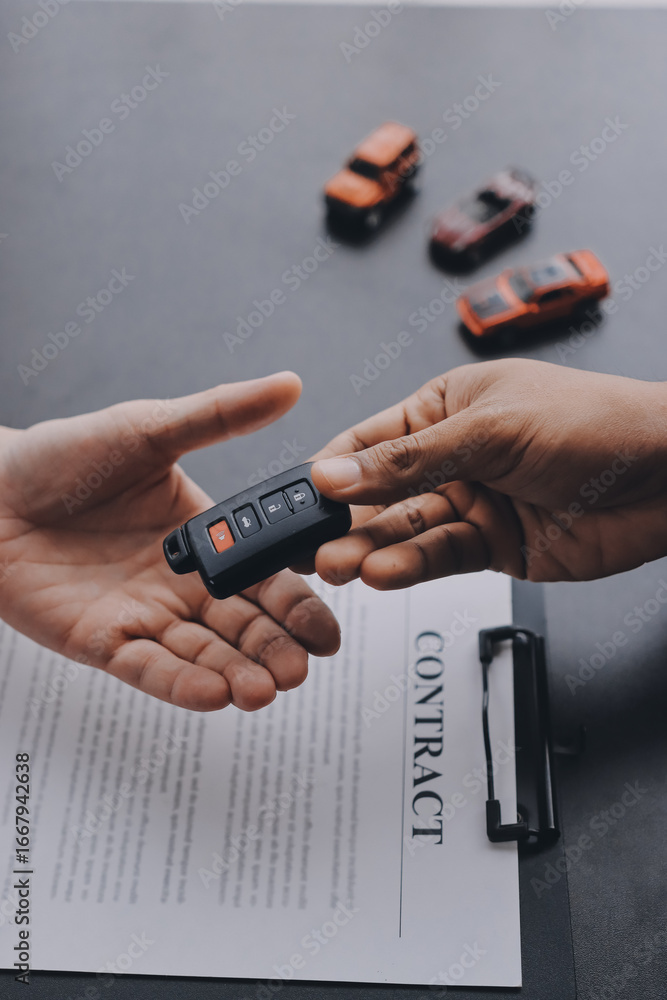 Fototapeta premium Car salesman gave the keys to the customers who signed the purchase contract legally, Successful completion of car sales, Purchase contract and key delivery.