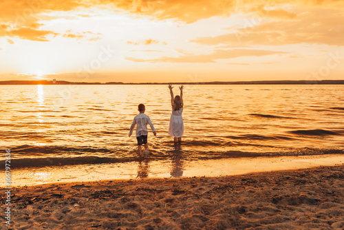 Φωτογραφία Joyful children playing in shallow water at golden sunset, sandy beach backdrop