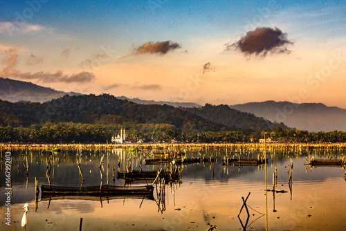 Fototapeta Naklejka Na Ścianę i Meble -  Mountain view with mosques and lakes with fish cages in the foreground, beautiful blue sky in the background