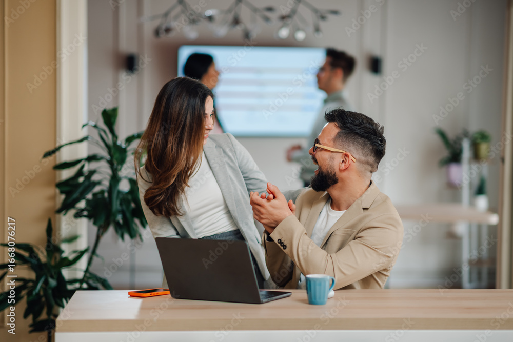 Fototapeta premium Business colleagues holding hands and laughing at the office