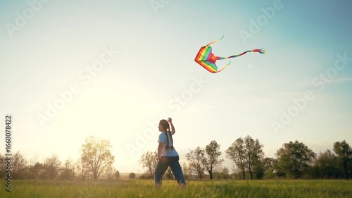 Person flying in field. Silhouette of young girl holding kite while running. Girl is running with a kite and a kite. An individual manipulating a kite in lifestyle a meadow.
