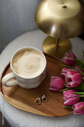 Cup with cappuccino, spring flowers tulips, morning concept, woman's day, bedroom design, gold modern desk lamp