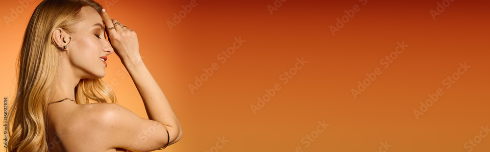 Fototapeta premium Stylish young woman showcasing modern fashion against a vibrant orange backdrop