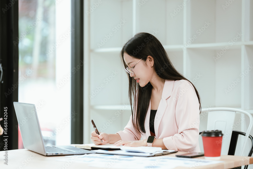 A confident businesswoman sits at her modern office desk with a laptop, smiling as she manages projects, collaborates online, and drives corporate success through technology, marketing, and profession A confident businesswoman sits at her modern office desk with a laptop, smiling as she manages projects, collaborates online, and drives corporate success through technology, marketing, and profession