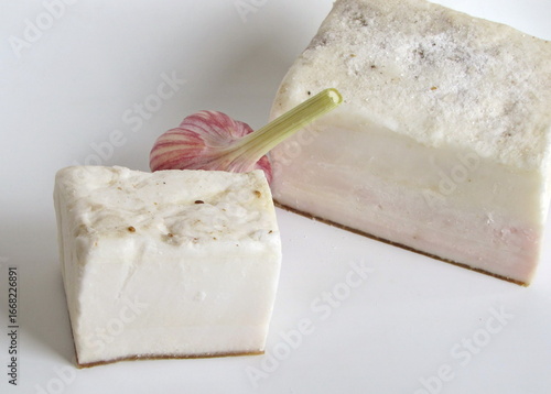 Salted lard on a white background and garlic.