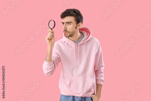 Young man with magnifier on...