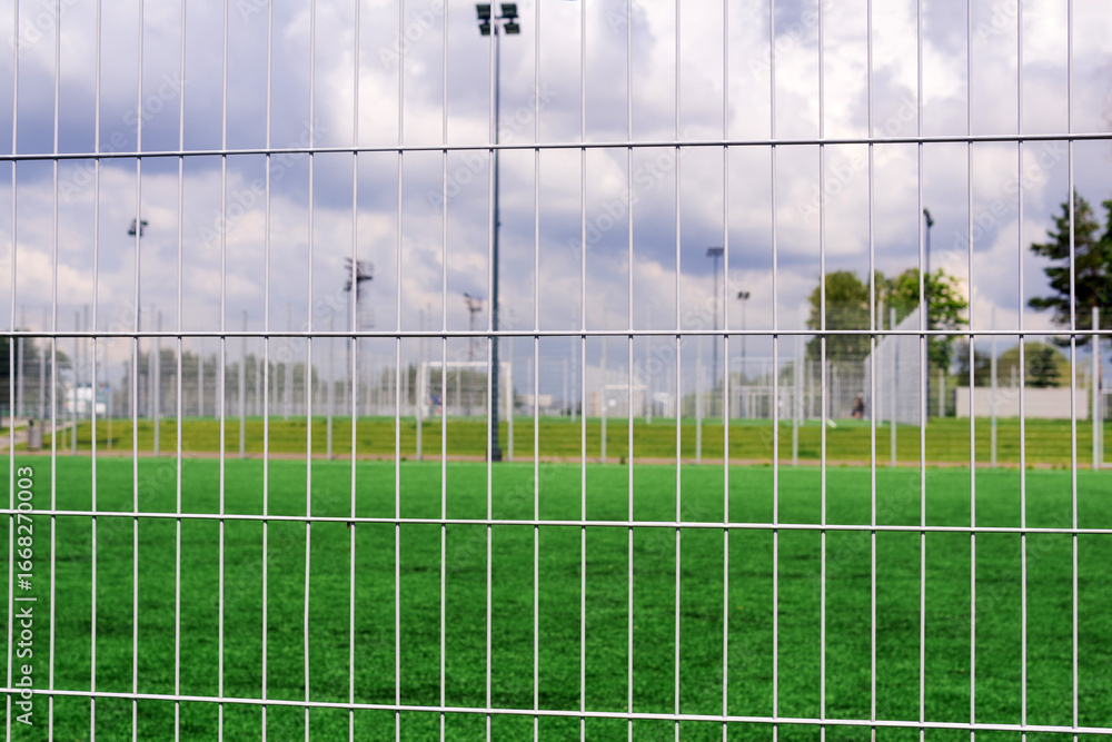 Obraz premium Sports grounds and soccer field behind the fence. The concept of sport and recreation